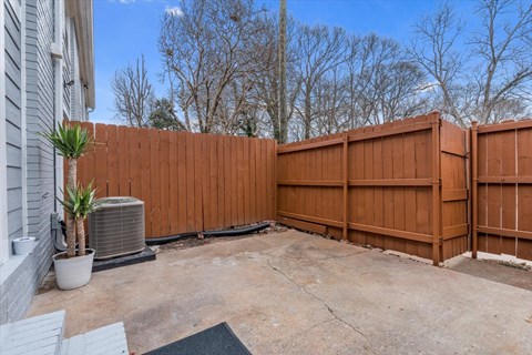 a backyard with a wooden fence and a potted plant