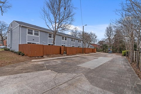 a blue house with a driveway and a wooden fence