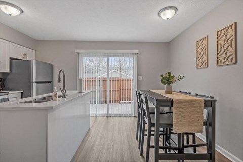 an open kitchen and dining area with a sliding glass door