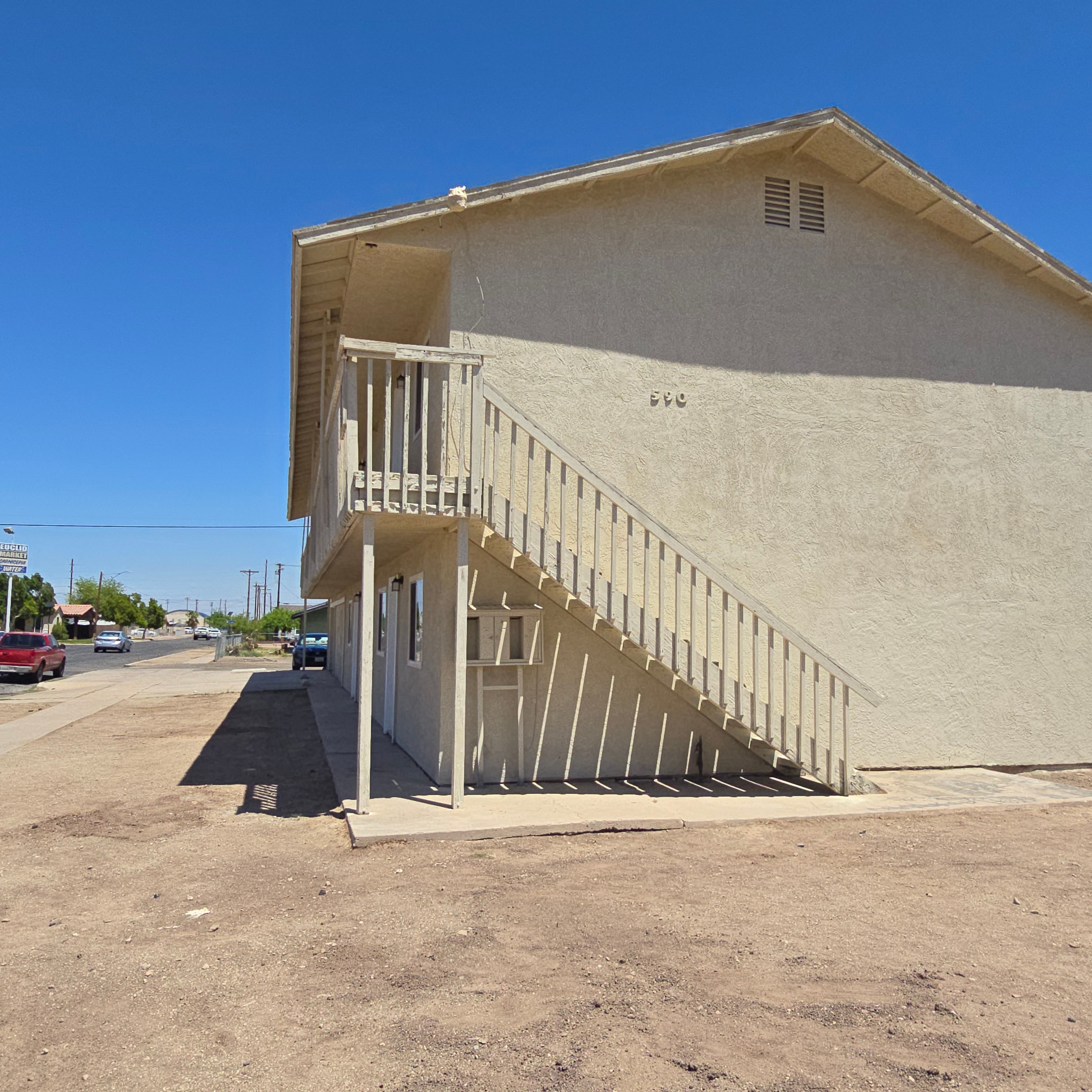 A beige building with a staircase leading to the entrance.
