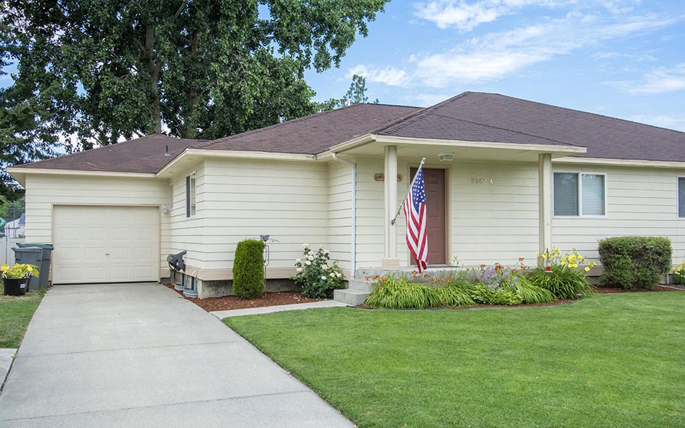 a white house with an flag in the front yard