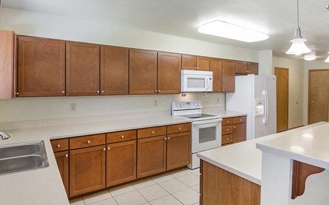 a kitchen with white appliances and wooden cabinets