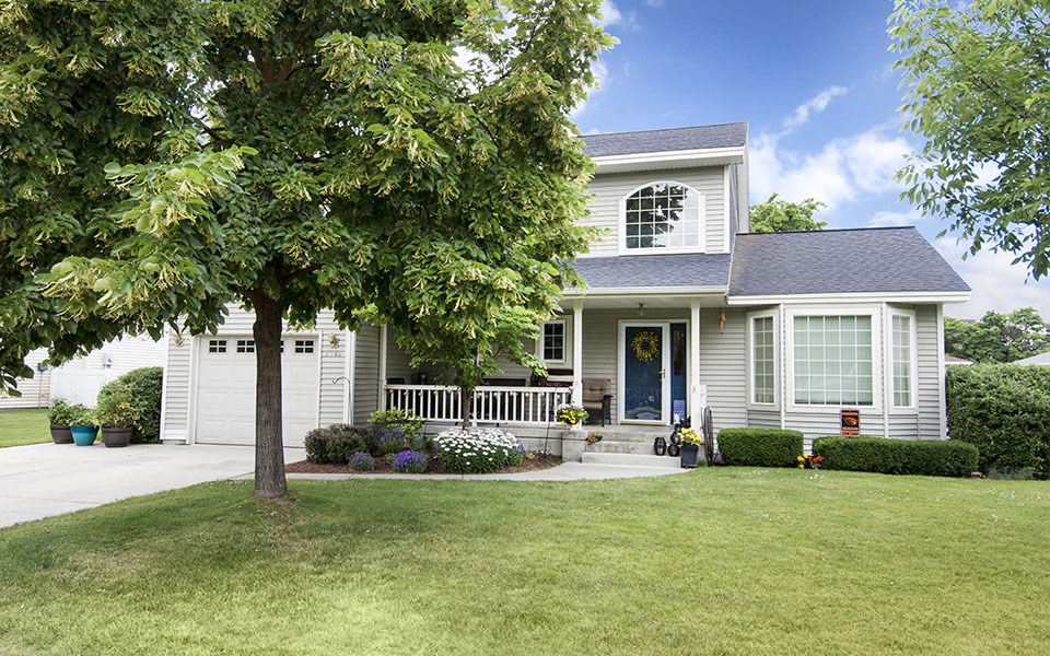a white house with a tree in front of it