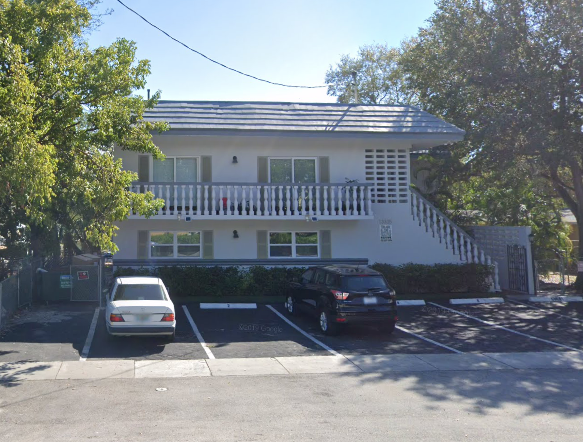 a white house with a car parked in front of it