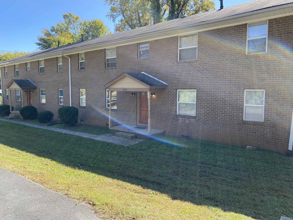 the front of a brick house with a lawn