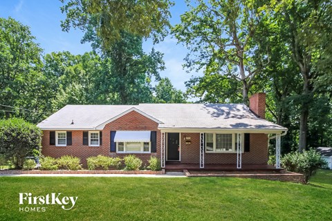 a brick house with a lawn and trees