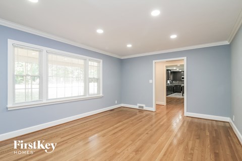 the living room of a house with blue walls and a wooden floor