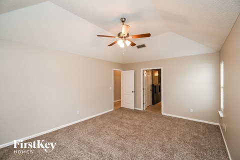 a living room with carpet and a ceiling fan