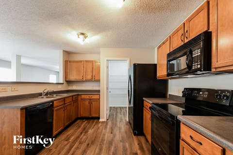 A kitchen with wooden cabinets and black appliances.