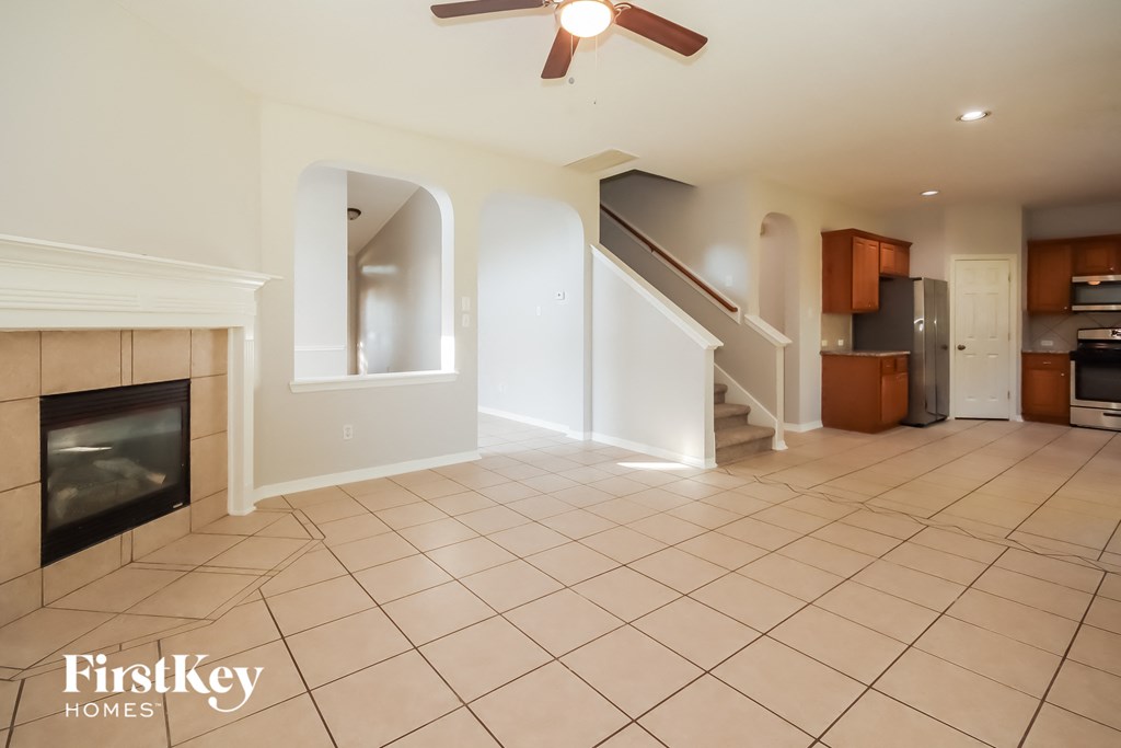 an empty living room with a fireplace and a staircase