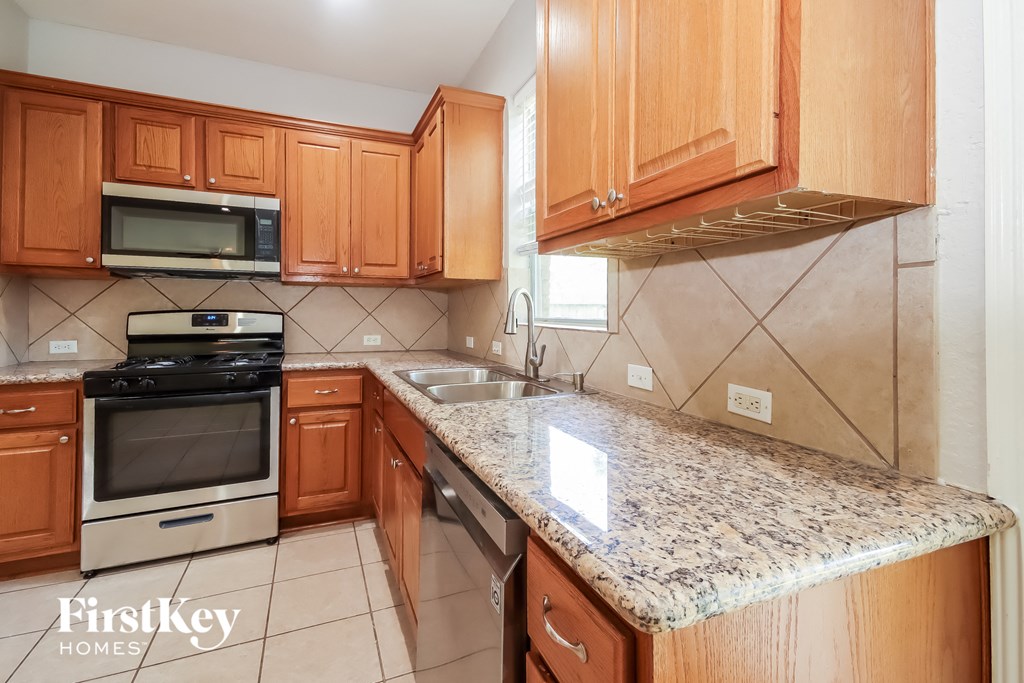 a kitchen with wooden cabinets and a granite counter top