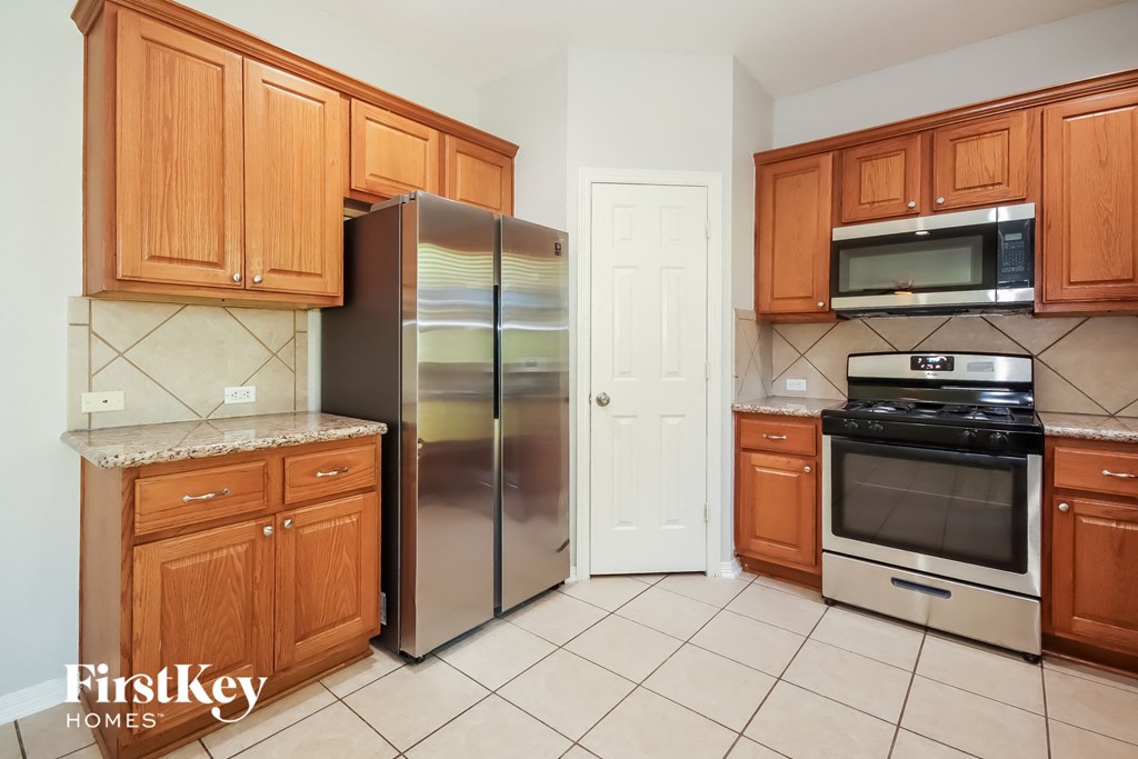 a kitchen with wooden cabinets and stainless steel appliances