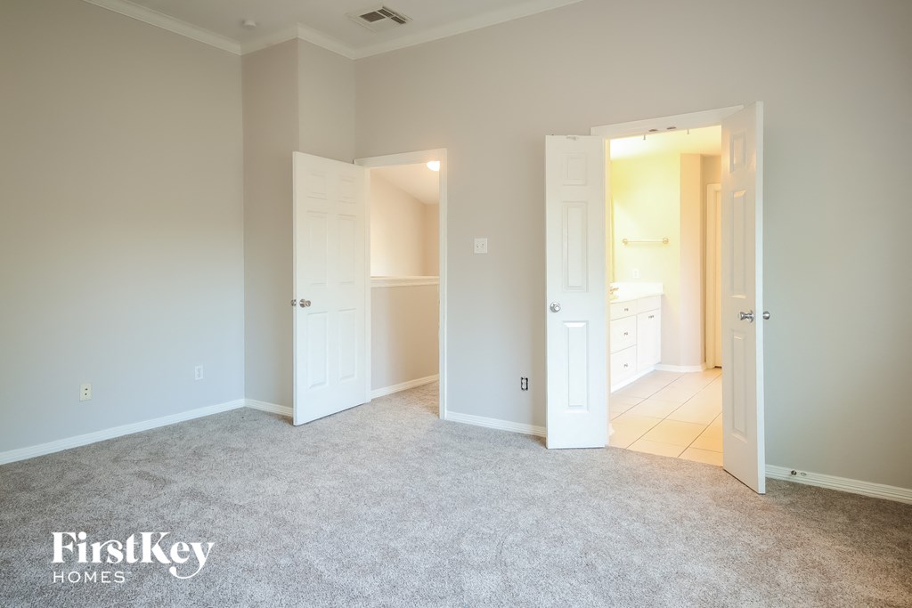 a bedroom with a carpeted floor and two closets