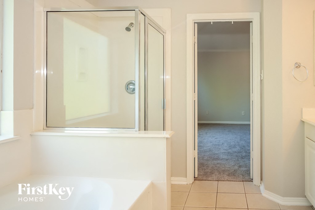 a white bathroom with a shower and a sink