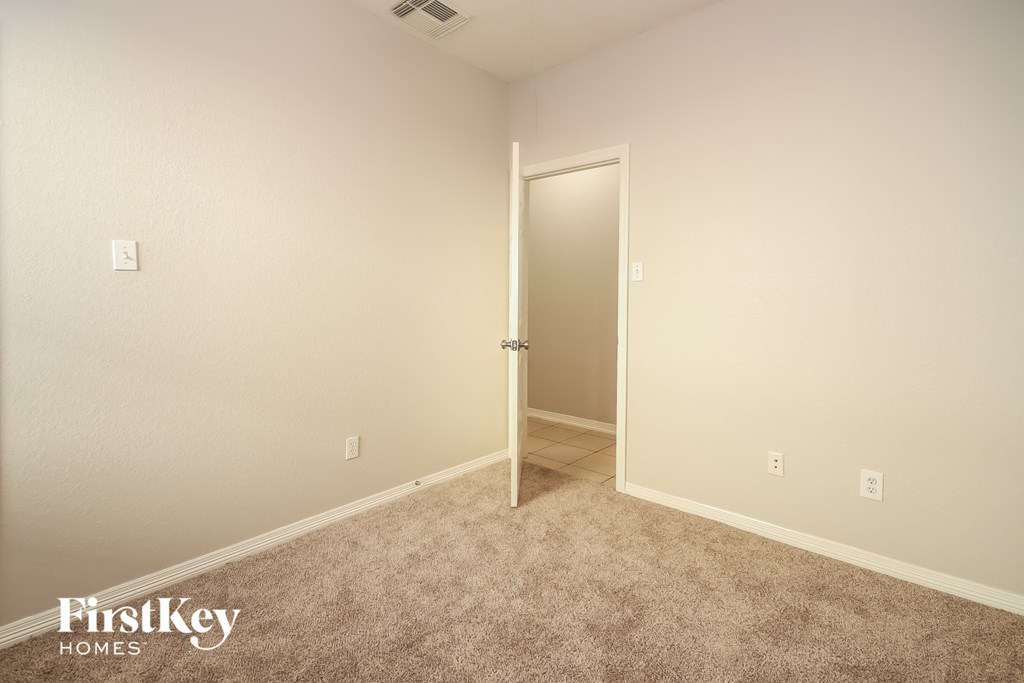 a bedroom with a door to a closet and a carpeted floor