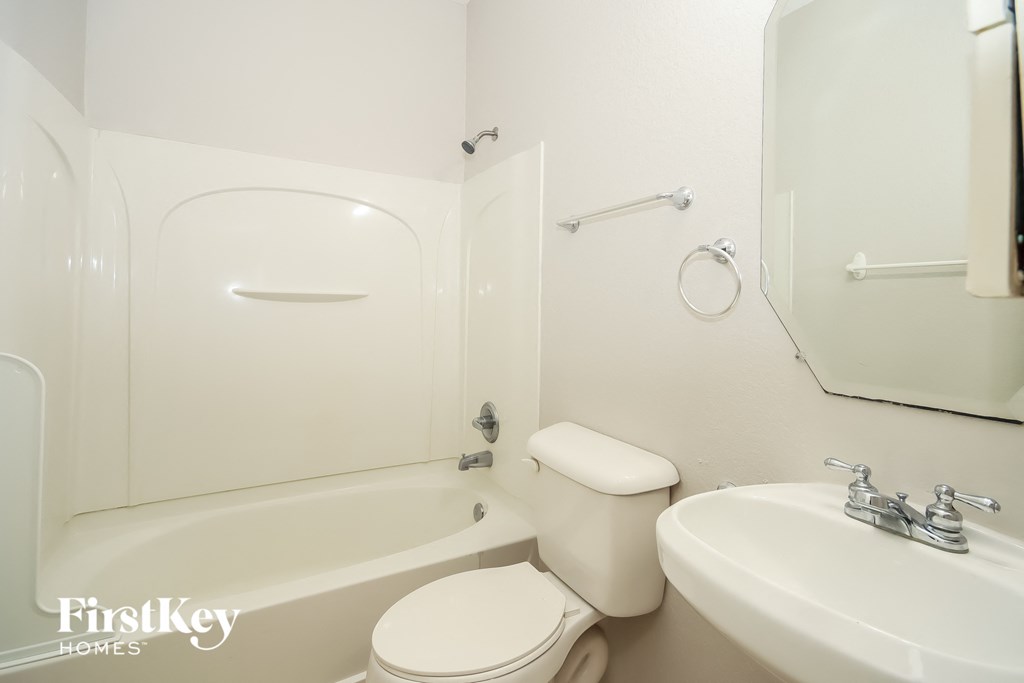 a white bathroom with a sink toilet and bath tub