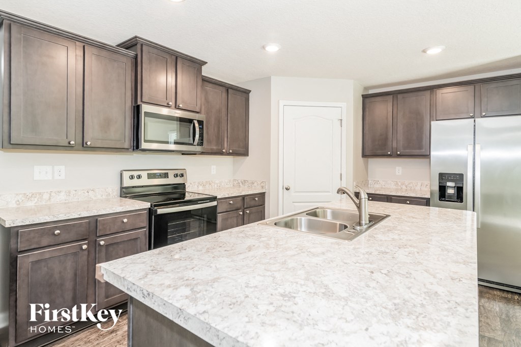 a kitchen with marble countertops and stainless steel appliances
