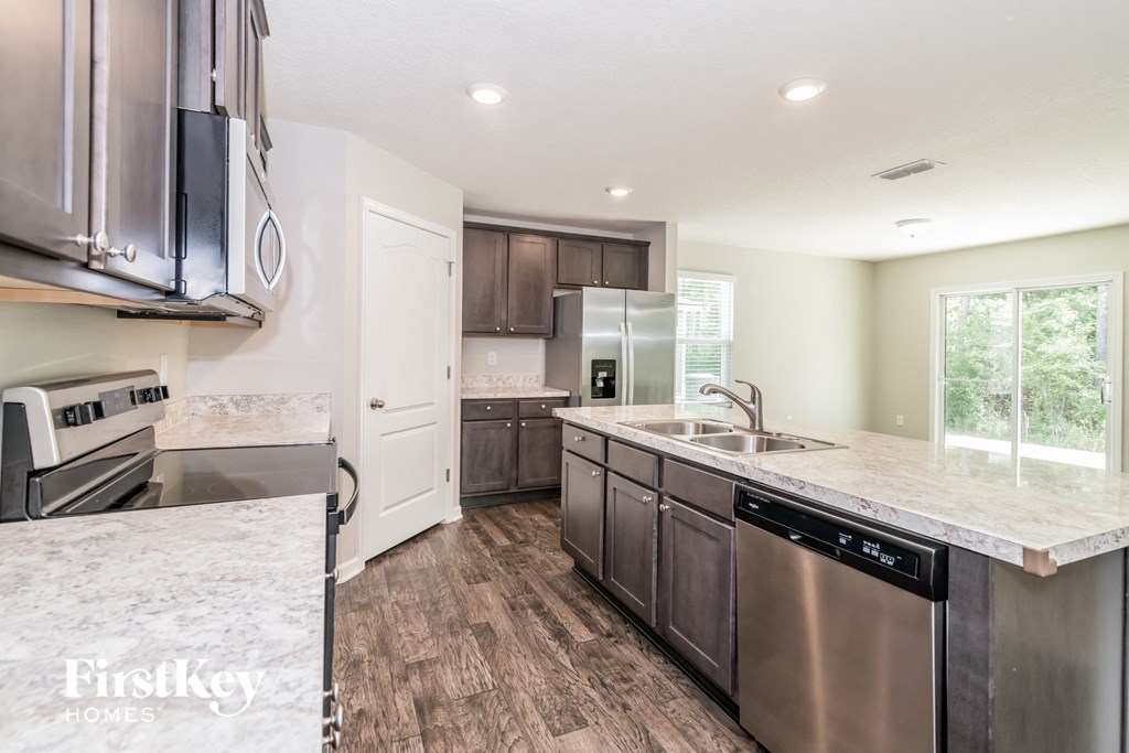an updated kitchen with stainless steel appliances and marble counter tops