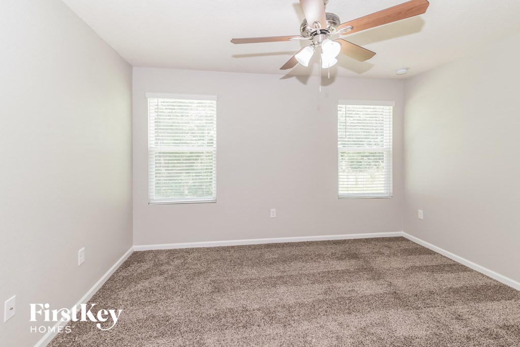 a room with carpet and a ceiling fan