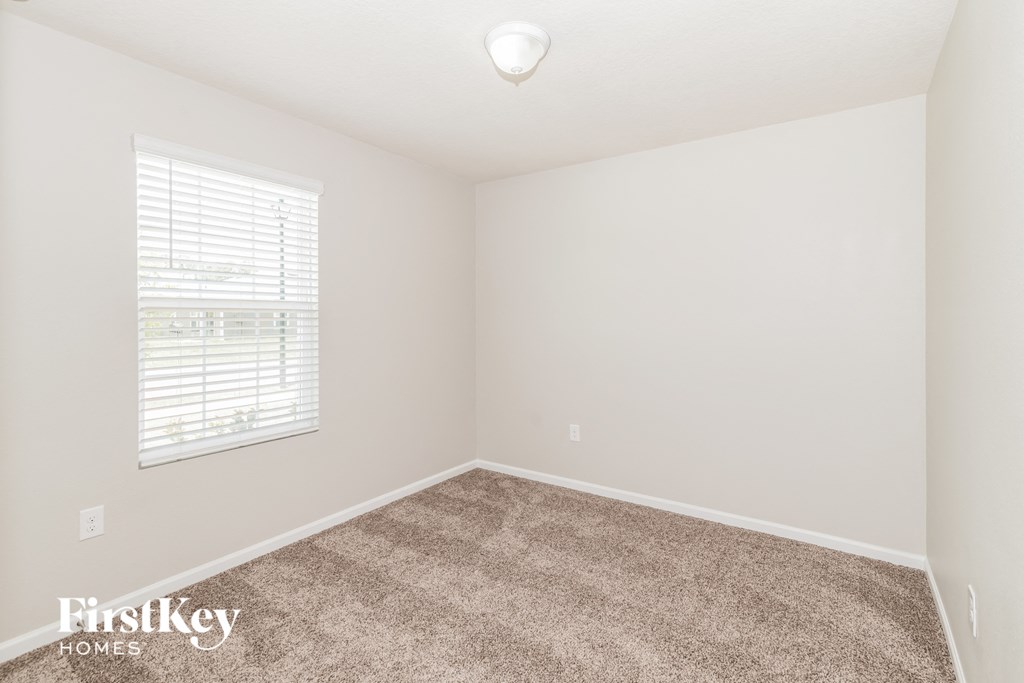 a bedroom with a carpeted floor and a window