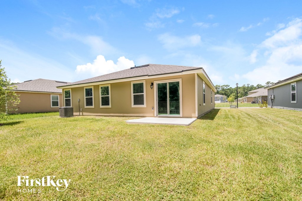 a home with a grassy yard and a brown house