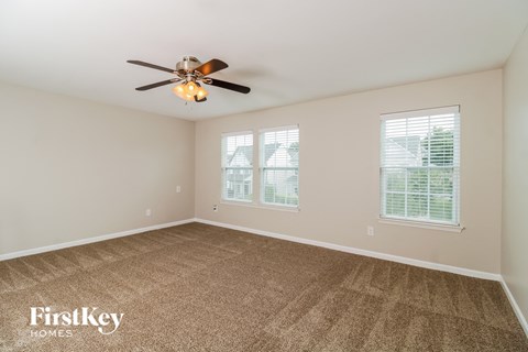 a living room with carpet and a ceiling fan