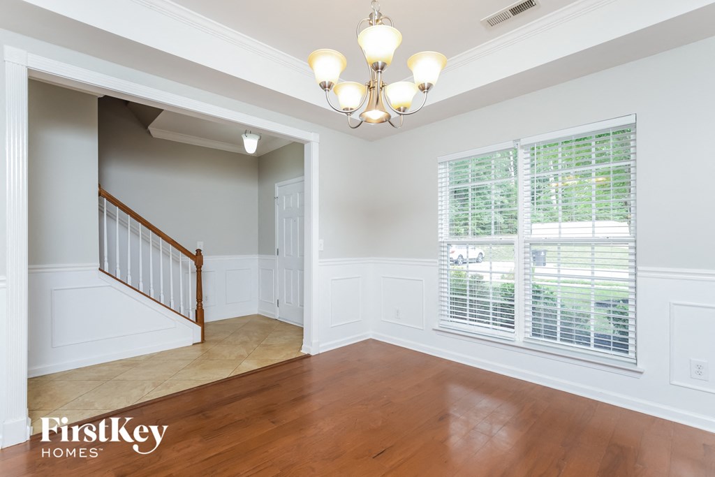 a living room with a staircase and a large window