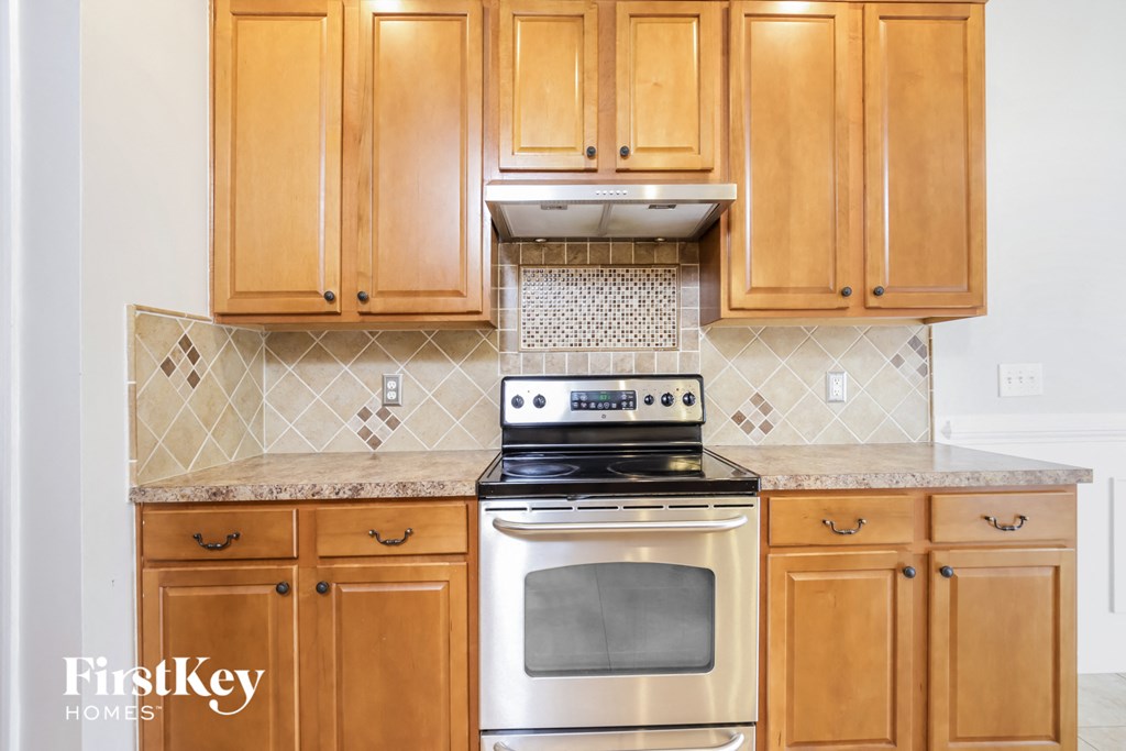 a kitchen with wooden cabinets and a stove and oven