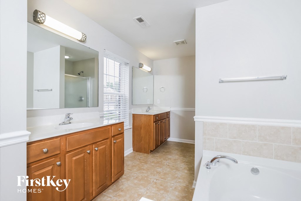 a bathroom with a tub and a sink and a mirror