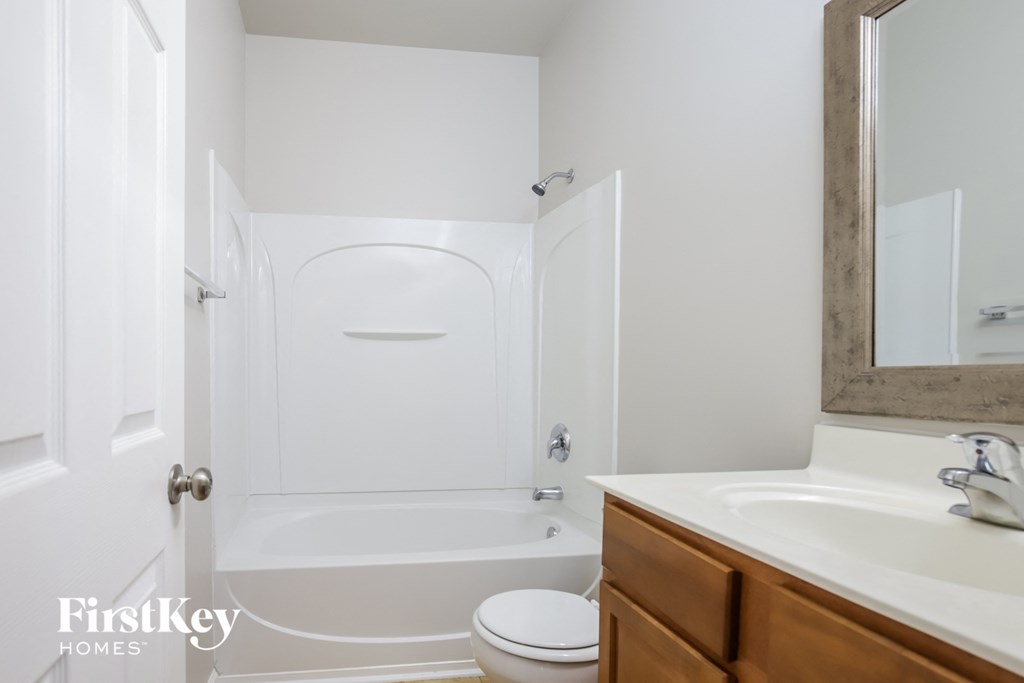 a white bathroom with a toilet and a sink and a shower