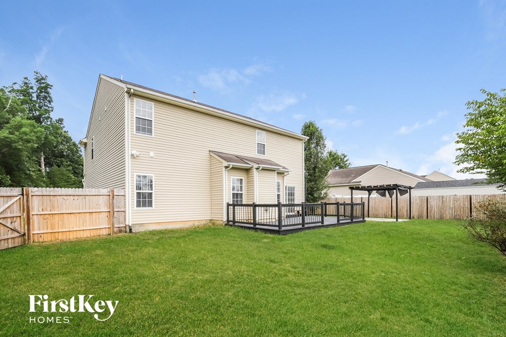 the backyard of a house with a yard and a fence