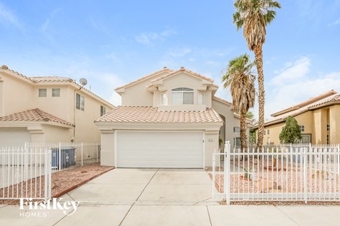 a house with a white fence and a palm tree