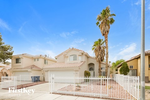 a house with a white fence and a palm tree