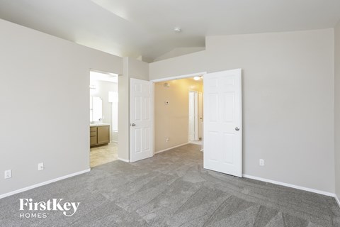 the living room and entryway of an empty house with white doors