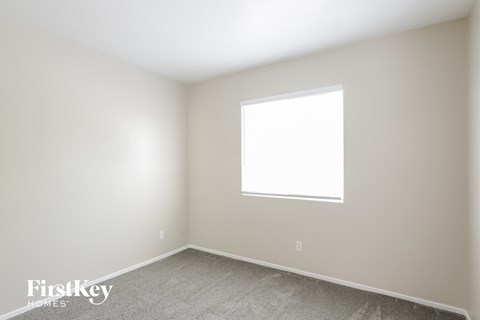 a white room with a window and a carpet