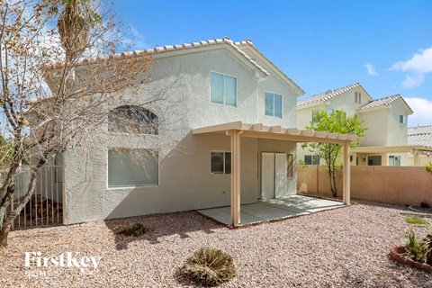 a white house with a covered porch and a tree