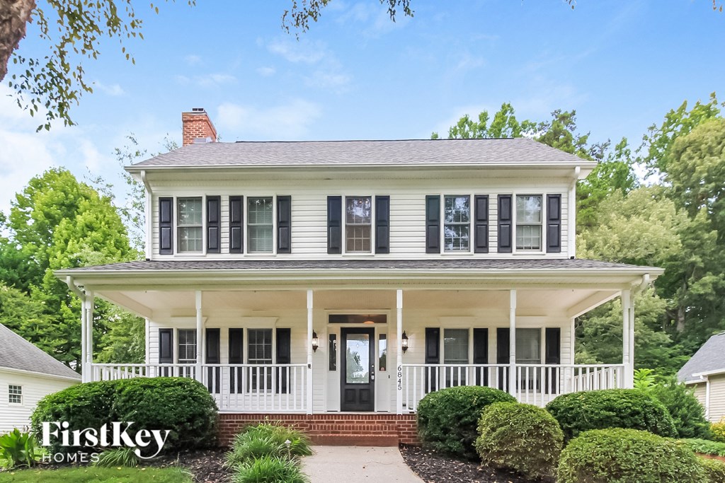 a white house with black shutters and a white porch