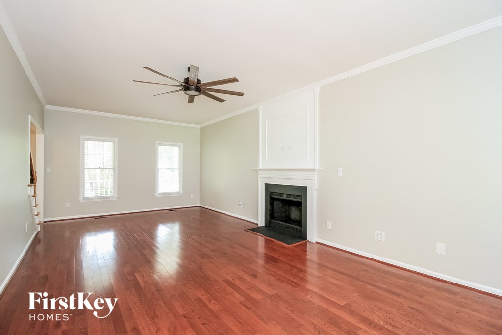 a living room with a fireplace and a ceiling fan