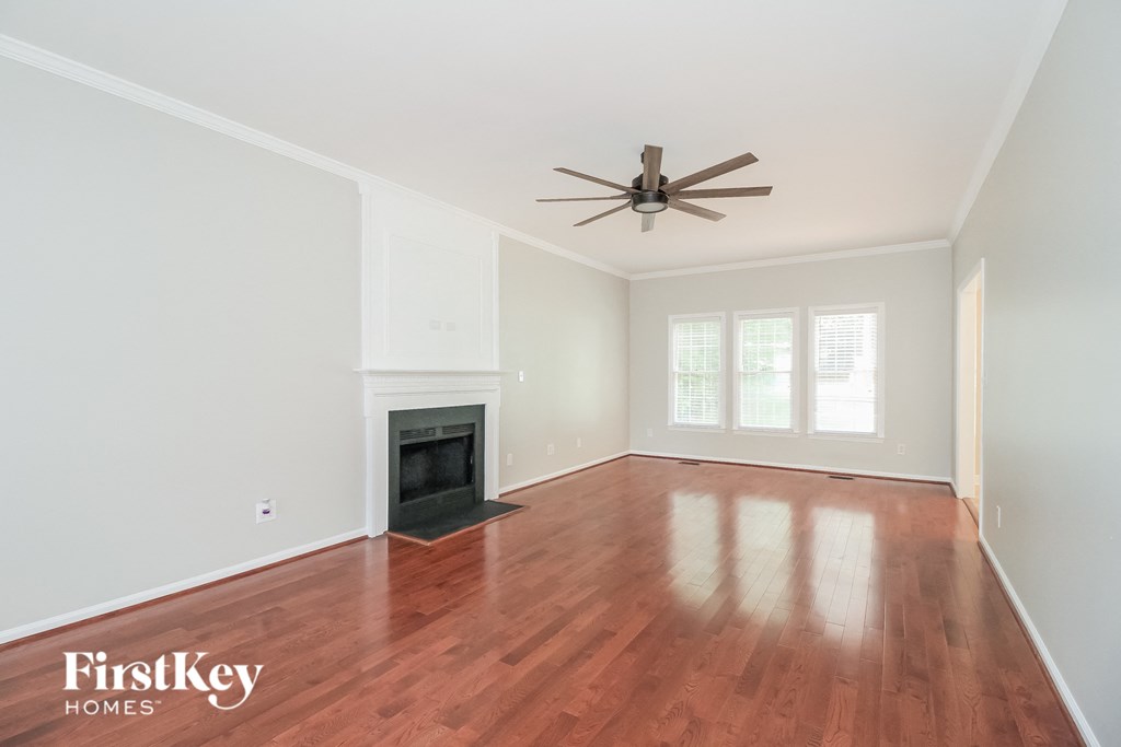 a living room with a fireplace and a ceiling fan