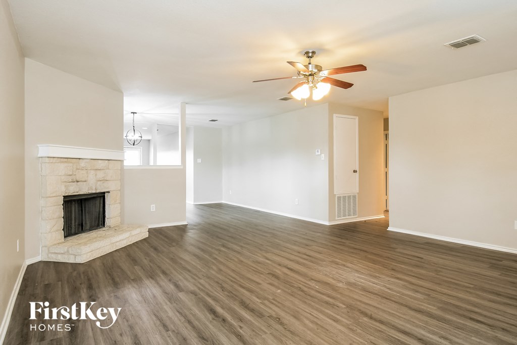 a living room with a fireplace and a ceiling fan