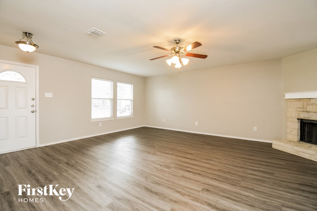 a living room with a fireplace and a ceiling fan