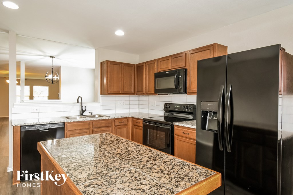 a kitchen with black appliances and granite counter tops