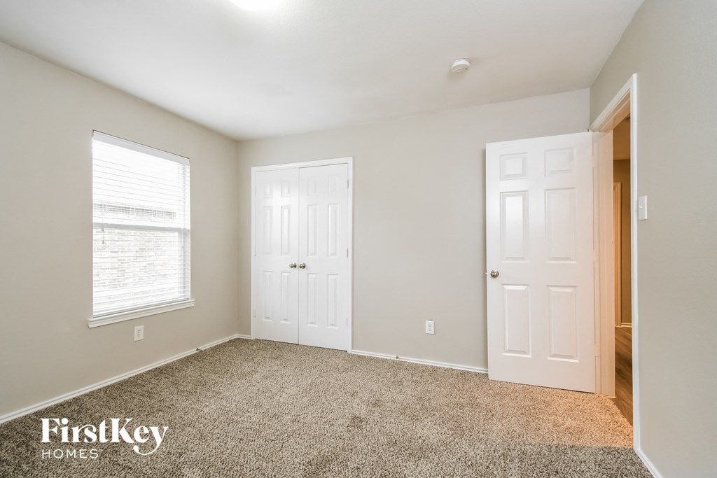 a bedroom with two doors and a carpeted floor