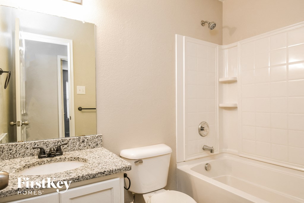 a bathroom with a toilet sink and tub and a mirror