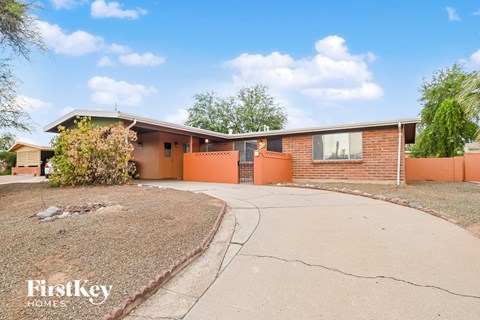 A house with a brown roof and orange walls is for sale.