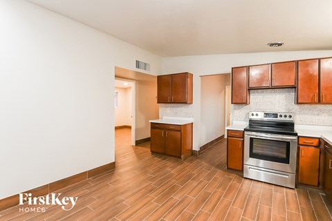 A kitchen with wooden cabinets and a stove top oven.