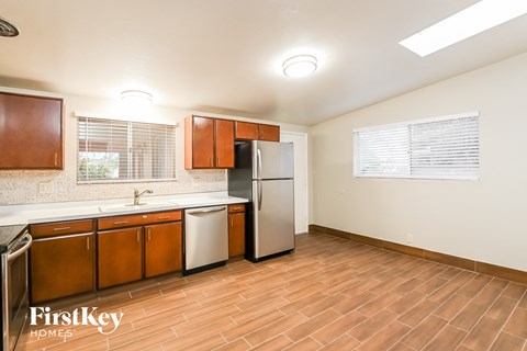 A kitchen with wooden cabinets and a refrigerator.