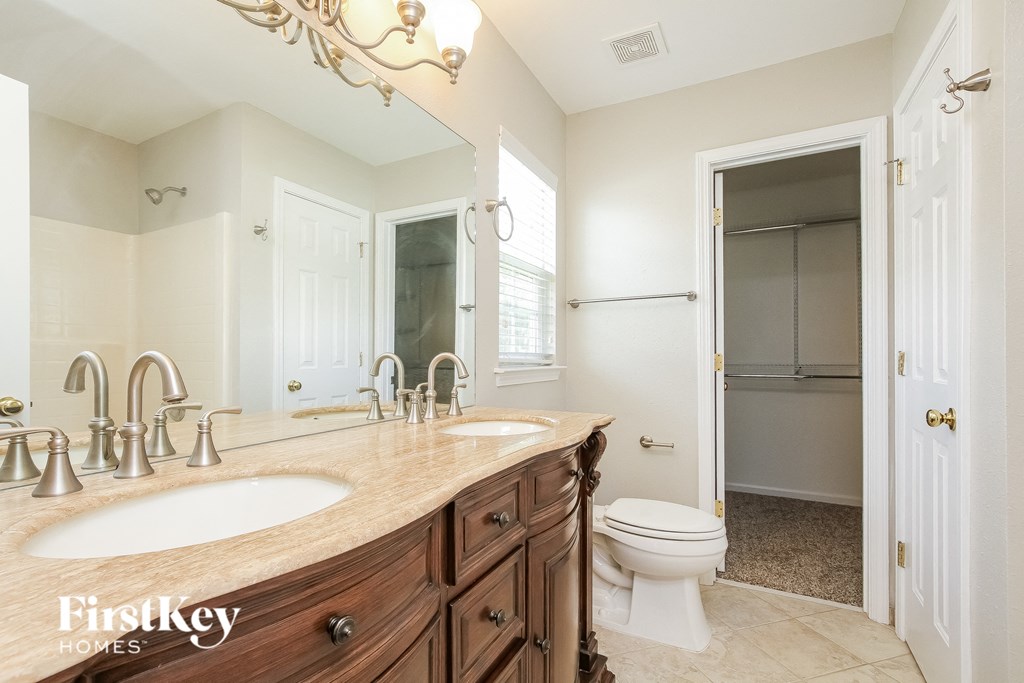 A bathroom with a wooden counter top and a walk in shower.