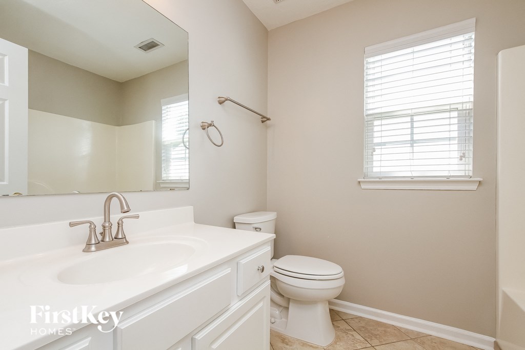 A bathroom with a white sink and toilet.