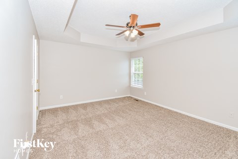 a living room with carpet and a ceiling fan
